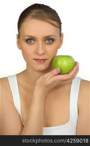 Young woman holding a green apple against her face