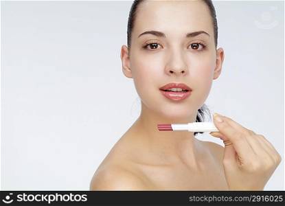 Young woman holding a lipstick