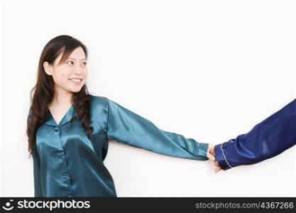 Young woman holding a man&acute;s hand and smiling