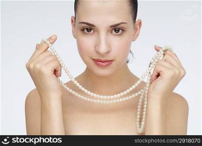 Young woman holding a necklace