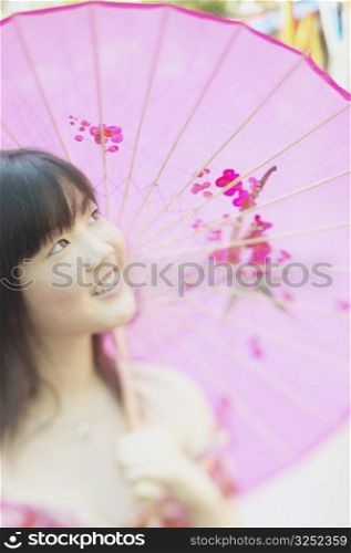 Young woman holding a parasol smiling