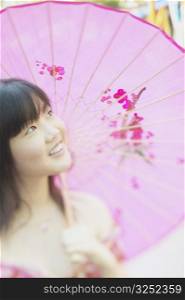 Young woman holding a parasol smiling