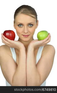 Young woman holding a red and a green apple