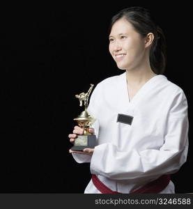 Young woman holding a trophy and smiling