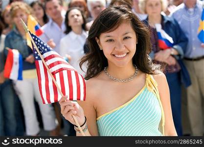 Young woman holding American flag, portrait