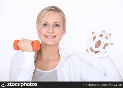 Young woman holding at sign and dumbbell