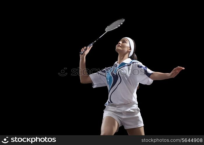 Young woman holding badminton racket isolated over black background