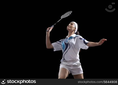 Young woman holding badminton racket isolated over black background