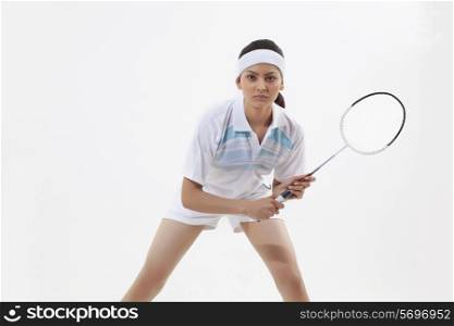 Young woman holding badminton racket isolated over white background