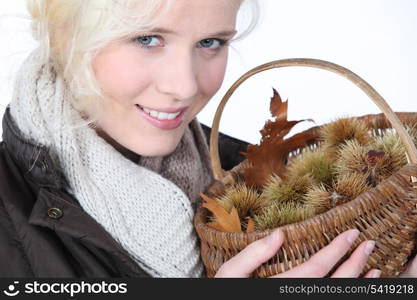 Young woman holding basket of chestnuts