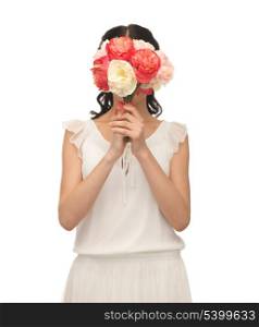 young woman holding bouquet of flowers over her face