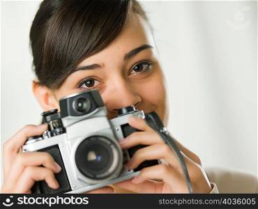 Young woman holding camera, portrait