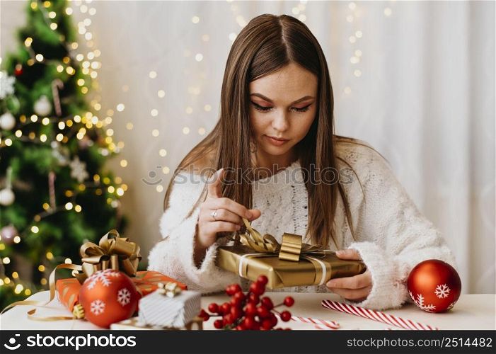 young woman holding christmas tree indoors 2