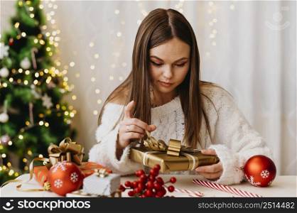 young woman holding christmas tree indoors 2