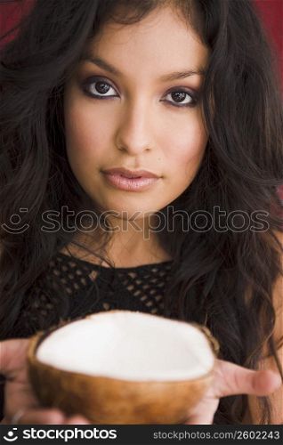 Young woman holding coconut