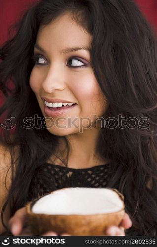 Young woman holding coconut