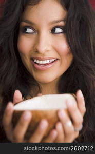 Young woman holding coconut