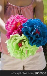 Young woman holding colorful paper flowers