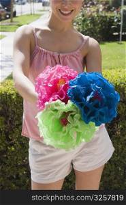 Young woman holding colorful paper flowers