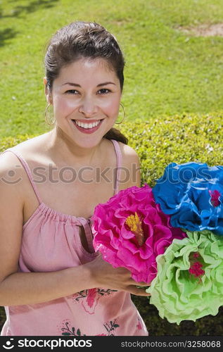 Young woman holding colorful paper flowers