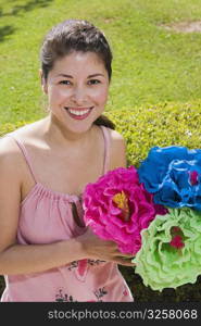 Young woman holding colorful paper flowers