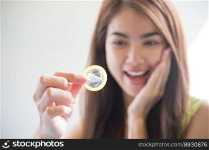 Young woman holding condom prevent pregnancy and Sexually transmitted diseases