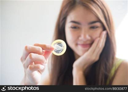 Young woman holding condom prevent pregnancy and Sexually transmitted diseases