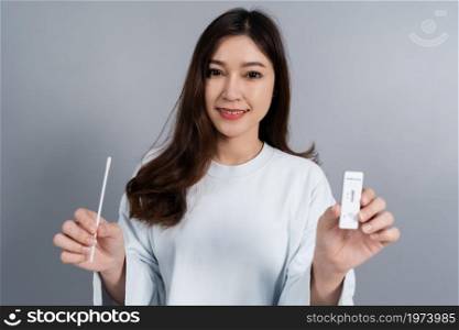 young woman holding Coronavirus(Covid-19) positive test result with SARS-CoV-2 Antigen Rapid Test kits for Self testing at home