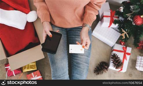 Young woman holding credit card and doing shopping online. New year, Christmas gift shopping.