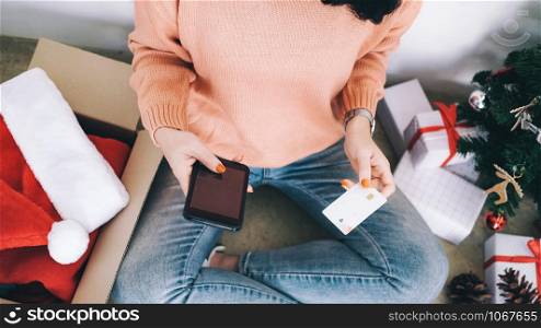 Young woman holding credit card and doing shopping online. New year, Christmas gift shopping.