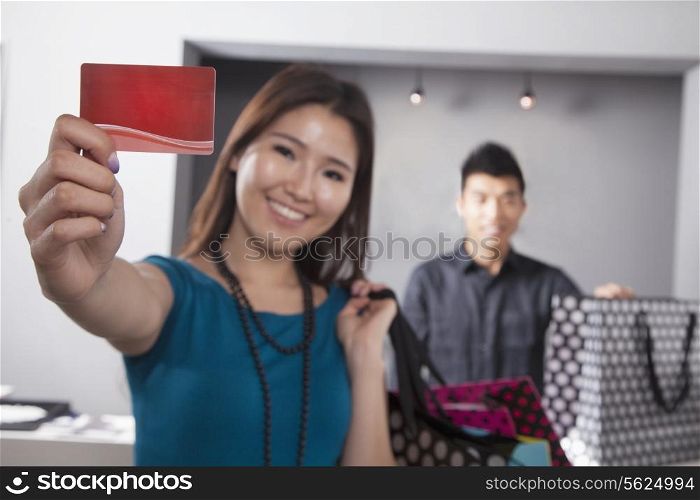 Young woman holding credit card at fashion store