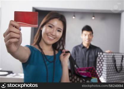 Young woman holding credit card at fashion store