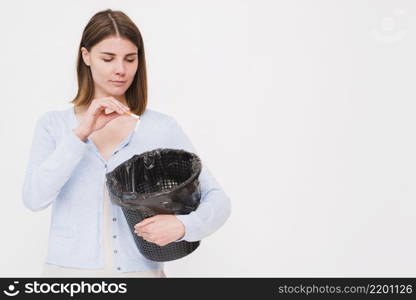 young woman holding dustbin throwing cigarette