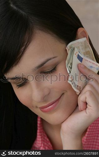 Young woman holding Euro notes in her hands and smiling