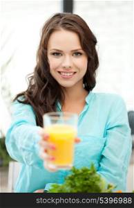 young woman holding glass of orange juice