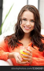 young woman holding glass of orange juice