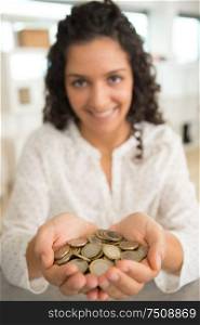 young woman holding heap of coins