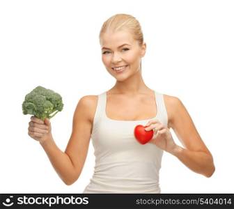 young woman holding heart symbol and broccoli