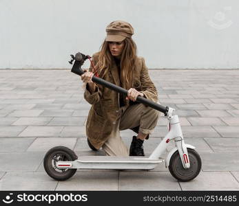 young woman holding her electric scooter