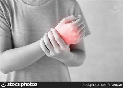 Young woman holding her wrist pain because using computer long time. De Quervain&rsquo;s tenosynovitis, Intersection Symptom, Carpal Tunnel Syndrome or Office syndrome.Disease and healthcare concept