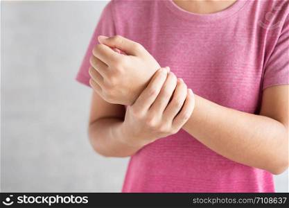 Young woman holding her wrist pain because using computer long time. De Quervain&rsquo;s tenosynovitis, Intersection Symptom, Carpal Tunnel Syndrome or Office syndrome.Disease and healthcare concept