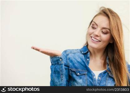 Young woman holding open palm. Girl in jeans outfit gesturing. Communication fashion leisure lifestyle concept. . Young woman holding open palm.