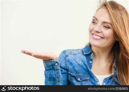 Young woman holding open palm. Girl in jeans outfit gesturing. Communication fashion leisure lifestyle concept. . Young woman holding open palm.