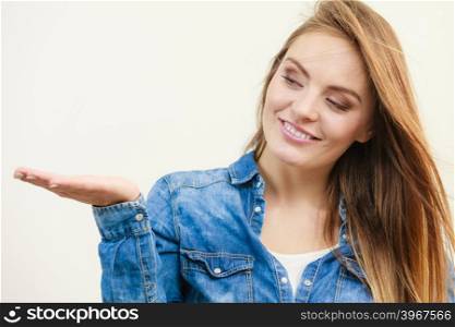 Young woman holding open palm. . Young woman holding open palm. Girl in jeans outfit gesturing. Communication fashion leisure lifestyle concept.