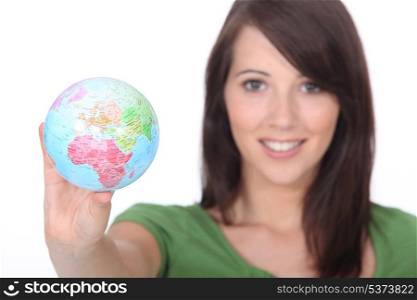young woman holding out world globe