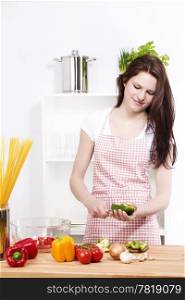young woman holding paprika while cutting it. young happy woman preparing green paprika for salad