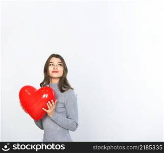 young woman holding red heart balloon hands
