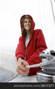 Young woman holding rope on yacht