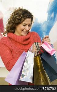 Young woman holding shopping bags and smiling