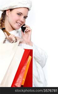young woman holding shopping bags and talking on her cell
